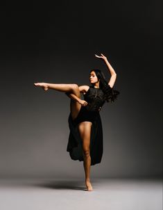 a woman in a black leotard is doing a dance move with her legs spread out