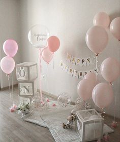 a room filled with balloons and confetti on top of a wooden floor next to a wall