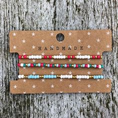 three bracelets with stars on them sitting on top of a wooden table