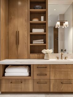 a bathroom with wooden cabinets and white towels