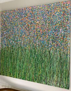 a painting on the wall with grass and flowers