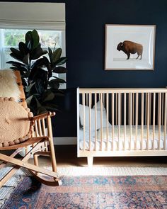 a baby's room with a rocking chair, crib and bear print on the wall