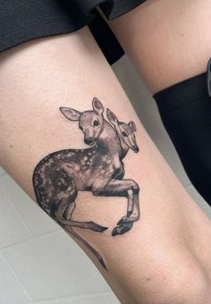 a black and white photo of a deer tattoo on the right calf's leg