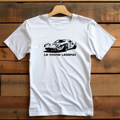 Ford fans! A classic unisex t-shirt that works well with any outfit. Made of a heavier cotton with a double-stitched neckline and sleeves. Buying as a gift? They'll love this classic car tshirt. Indulge in the thrilling world of classic cars with this revival T-Shirt. This vintage retro inspired design encapsulates the passion, nostalgia, and unmatched quality that every automotive enthusiast craves. 🏁 Vintage Racing Passion: Feel the pulse of the racetrack with this captivating design featurin White T-shirt With Motorsport Letter Print, White Letter Print T-shirt For Motorsport Events, Cars Tees, Car Gift, American Classic Cars, Car Gifts, Fan Shirts, American Classic, Vintage Racing