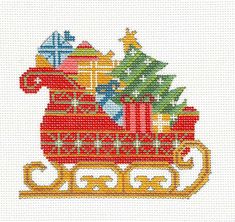 a cross stitch christmas sleigh with presents on it and a tree in the center