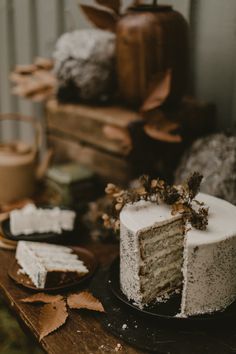 a white cake sitting on top of a wooden table next to other cakes and desserts