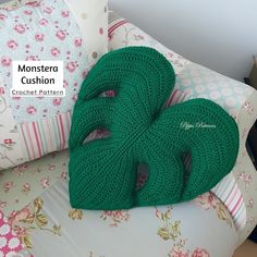 two green crocheted pillows sitting on top of a couch