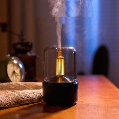 a steam lamp sitting on top of a wooden table