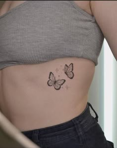 a woman with a butterfly tattoo on her stomach