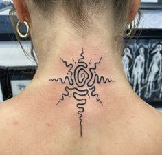 a woman's back neck with a tattoo design on the upper part of her neck