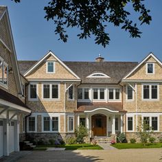 a large brown house with lots of windows and white trim on it's sides