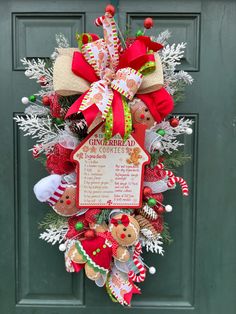 a christmas wreath with gingerbread cookies and candy canes hanging on the front door