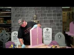 a man in black shirt and blue gloves working on a pink tombstone