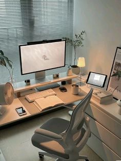 a computer desk with two monitors and a laptop sitting on it's side, in front of a window