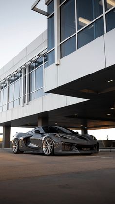 a silver sports car parked in front of a building