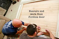 two men working on a wooden door with the words measure and mark faux firebox door