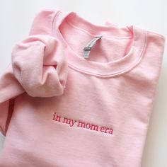 In my mom era Embroidered Sweatshirt - Cotton and polyester blend - Unisex fit - The design is embroidered  C A R E : I recommend turning the item inside out and wash cold on delicate cycle. Air dry for best result. Do not iron directly on the embroidery surface. PLEASE NOTE  - Actual color may vary due to variations in display settings. - Please check out our size chart for measurements to ensure an accurate fit. - Sales are final. No returns, exchanges or refunds. Please feel free to ask if you have any questions. ★ Click here to see more crewnecks in my shop : https://etsy.me/3qQd7Ya Embroidered Mom Sweatshirt, Pink Sweatshirt Embroidered, Pink Embroidered Relaxed Fit Sweatshirt, Mother's Day Embroidered Crew Neck Sweatshirt, Mother's Day Embroidered Cotton Sweatshirt, Pink Crewneck Sweatshirt, Pink Crewneck, Embroidered Sweatshirts, Personalized Shirts