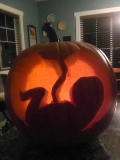 a carved pumpkin with a shadow of a person on it