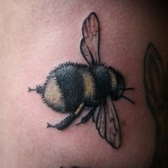 a bee tattoo on the back of a woman's stomach