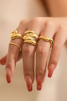 a woman's hand with three gold rings on it