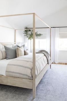 a bed with white sheets and pillows in a bedroom