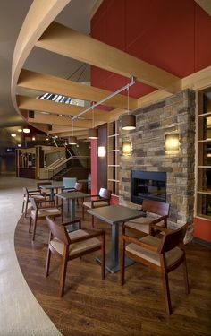 an empty restaurant with tables and chairs in front of a fire place that is built into the wall