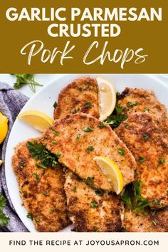 garlic parmesan crusted pork chops on a white plate with lemon wedges