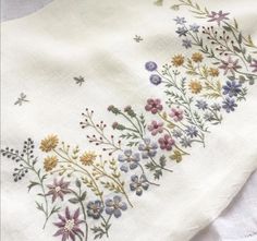 an embroidered piece of cloth with flowers on it