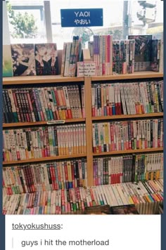 a book shelf filled with lots of books next to a wall covered in pictures and text