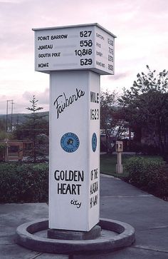 a white sign sitting on the side of a road