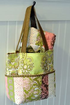 a bag hanging from the side of a door with several different fabrics in it,