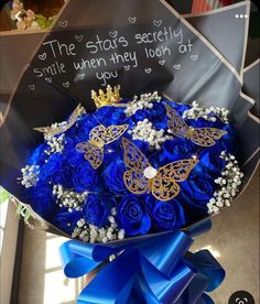 a bouquet of blue roses in a box that says the stars society smile when they look at you