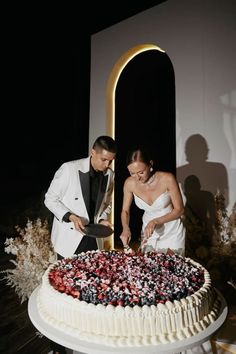 a bride and groom cutting their wedding cake