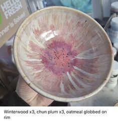 a hand holding a pink and white bowl