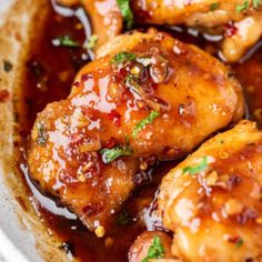 chicken wings with sauce and parsley in a white bowl