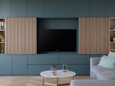 a living room filled with furniture and a flat screen tv mounted on a wall above a coffee table