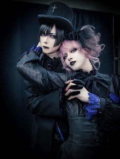 two women dressed in gothic clothing posing for the camera with their arms around each other