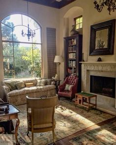 a living room filled with furniture and a fire place in front of a large window