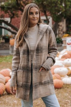 Details Update your outerwear this season with this stylish Taupe Plaid Hooded Open Knit Coat! It's perfect for workwear or any casual occasion. Features long sleeves, an attached hood, open front, side pockets, and an allover plaid pattern. Layer over a neutral basic tank or bodysuit and then pair with your favorite denim jeans, ankle booties, and a trendy tote bag to complete the look. Long sleeve Open front Attached hood Front pockets Plaid pattern Straight silhouette Knit fabric 74% Acrylic, Hooded Cardigan With Pockets For Fall, Fall Hooded Cardigan With Pockets, Cozy Hooded Cardigan With Pockets, Hooded Fall Cardigan With Pockets, Brown Hooded Sweater Coat For Fall, Cozy Long Coat For Fall, Brown Hooded Sweater Coat For Cold Weather, Winter Hooded Jacket For Workwear With Long Sleeves, Winter Workwear Hooded Jacket With Long Sleeves