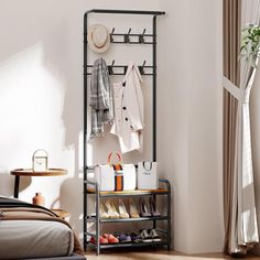 an iron rack with shoes and purses on it in a bedroom next to a bed