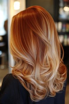 Woman with long, wavy, red and blonde balayage hair in a salon. Dark Auburn Hair Blonde Highlights, Auburn Hair Ombre, Ginger Hair Color With Blonde Highlights, Reddish Blonde Hair With Highlights, Auburn And Blonde Hair, Blonde Copper Hair Color, Red Blonde Balayage, Deep Auburn Hair Color, Fall Red Hair