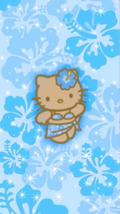 a hello kitty pin sitting on top of a blue and white flowered wallpaper