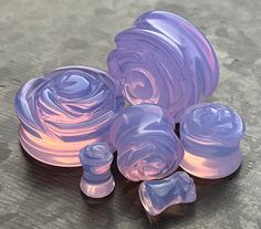 three purple swirls sitting on top of a wooden table next to an object that looks like something out of space