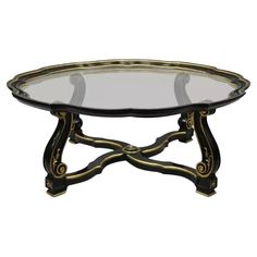 an oval glass table with gold trimmings and a metal frame around the edge