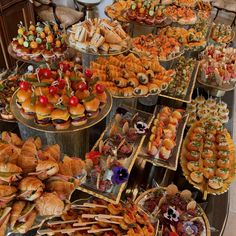 a table filled with lots of different types of sandwiches and pastries on trays