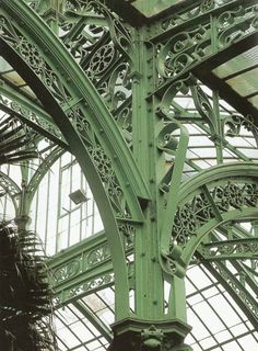 the inside of a building with many windows and green metalwork on it's sides