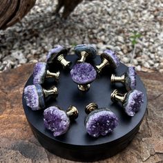 purple and gold plugs sitting on top of a rock