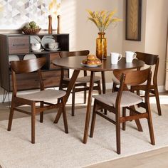 a dining room table with chairs and a vase