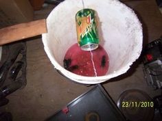 a red ball of yarn in a white bowl with a green can on it and a laptop