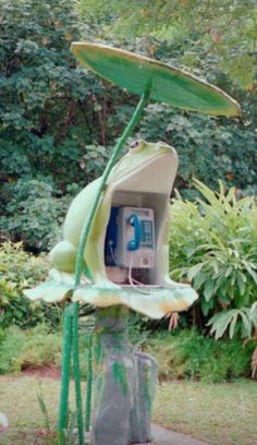 an outdoor phone booth in the middle of a garden